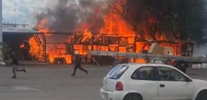 Personas corriendo cerca de un incendio en San Martín Texmelucan, Puebla.