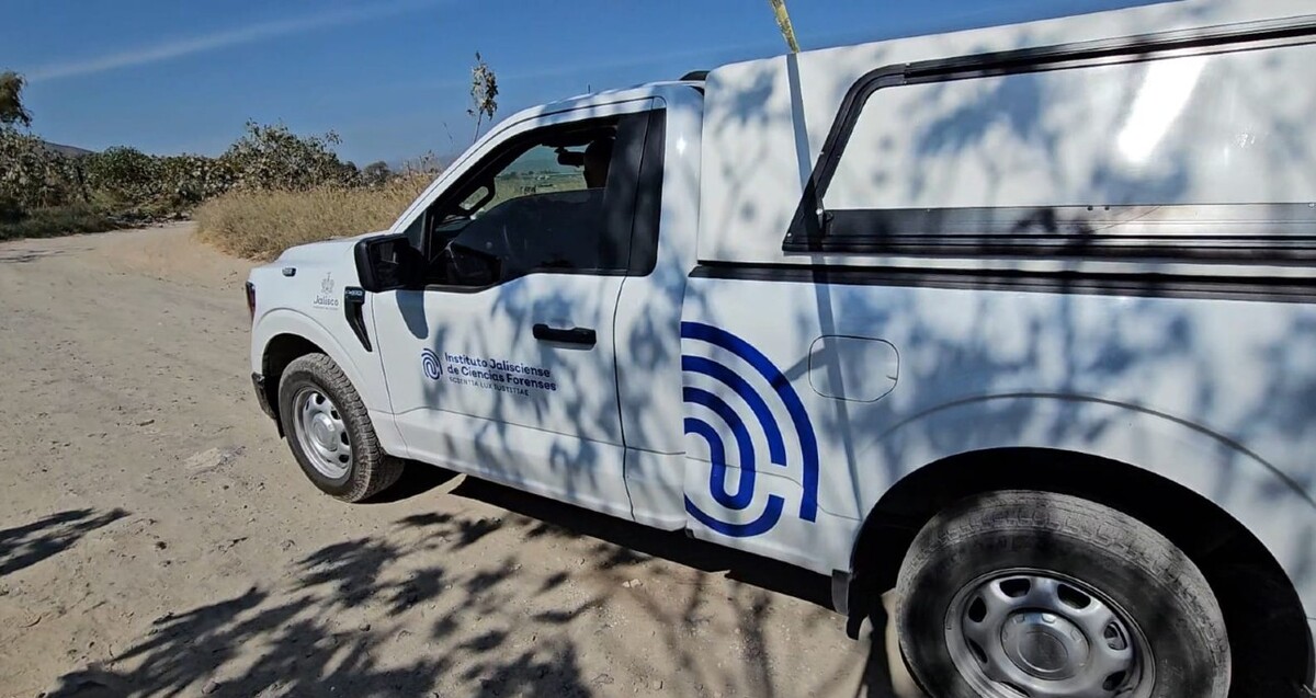 Camioneta del Instituto Jalisciense de Ciencias Forenses con una persona conduciendo sobre un camino de tierra y matorrales a los costados