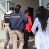 Elementos de la Fiscalía del Estado de Michoacán portando sus uniformes y escoltando al comerciante rescatado que camina en medio y viste una playera roja