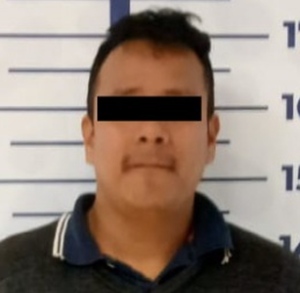 Hombre detenido con una cinta negra sobre sus ojos, respetando su presunción de inocencia.