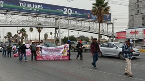 Se ven personas caminando sobre un bulevar con una pancarta en las manos.