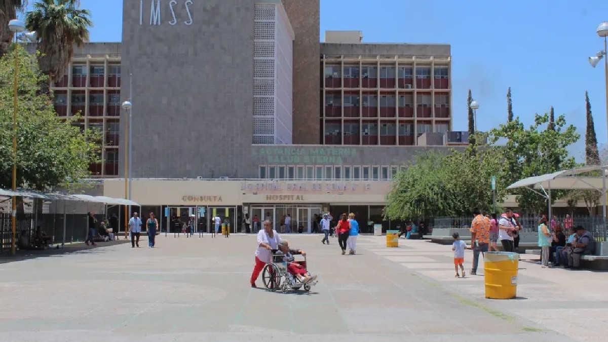Edificio del IMSS en color verde rodeado de decenas de personas
