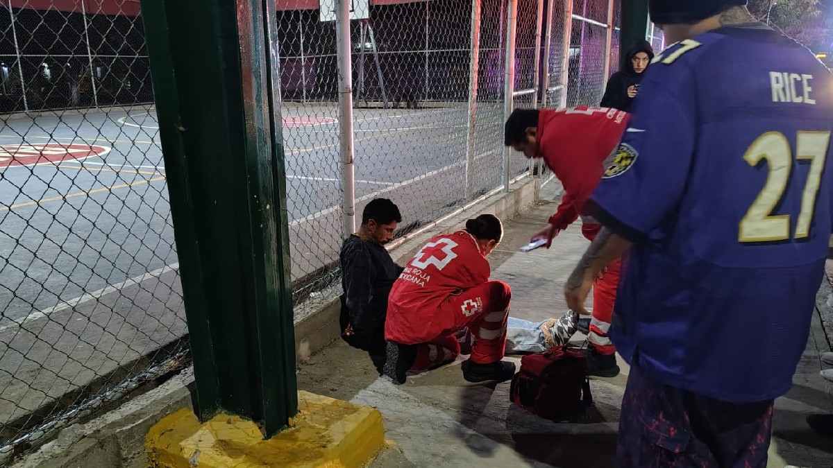 Imagen de paramédicos atendiendo a un hombre que experimentaba fuertes dolores, tendido en el piso.