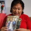 una mujer sostiene unas fotografías de su hijo desaparecido en puebla