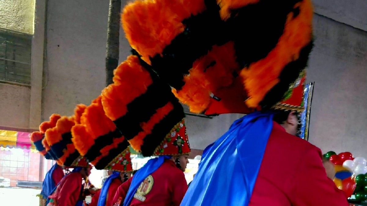 Hombres con penachos en color azul y naranja