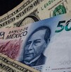 Billete mexicano entre dólares estadounidenses.