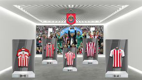 Una exhibición de la historia de Chivas en un museo, mostrando cinco camisetas históricas del club en vitrinas transparentes, con una foto del equipo campeón de