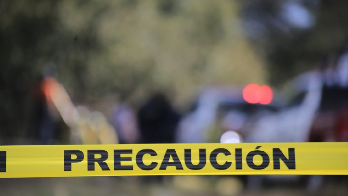 Cinta amarilla de prohibido el paso delante de una patrulla de policía