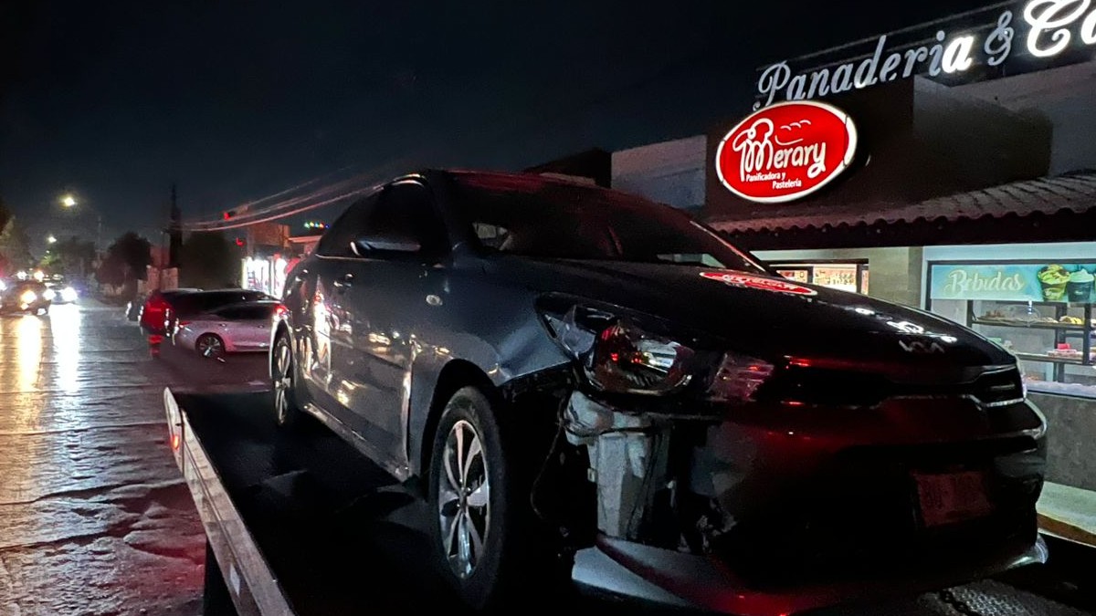 Camioneta en color gris y chocada arriba de una grúa