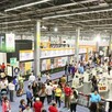 Multitud de personas recorriendo los pasillos dentro de la Expo Guadalajara con carteles, stands, libros y carteles