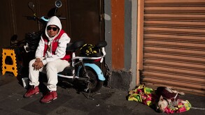 Mujer con lentes de Sol descansando junto a un perrito en calles de la Ciudad de México.