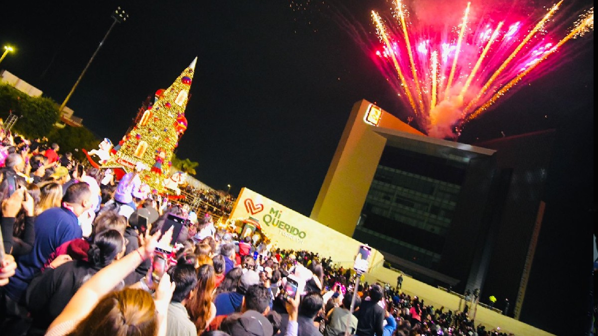 Explanada de la Plaza Mayor de Torreón llena de gente viendo la pirotecnia durante el encendido del pino de Navidad.