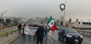 Se observa a un grupo de personas caminando con una lona en sus manos.