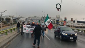 Se observa a un grupo de personas caminando con una lona en sus manos.
