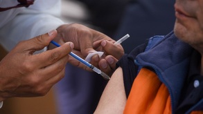 Una persona siendo vacunada por una enfermera.