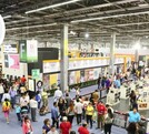 Multitud de personas recorriendo los pasillos dentro de la Expo Guadalajara con carteles, stands, libros y carteles