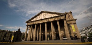 Vista en contrapicado del Teatro Degollado en Guadalajara. El edificio neoclásico tiene un gran pórtico de columnas dóricas y un frontón con un bajorrelieve.
