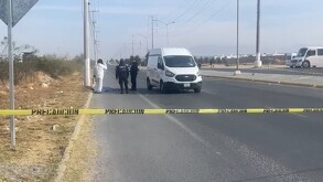 Se observa un hombre tendido en el suelo, una cinta de precaución amarilla y una camioneta blanca.