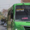 Vista frontal de un camión color verde de la ruta 50B circulando por calles de Guadalajara con casas y autos alrededor