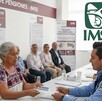 Adultos mayores en México realizando el trámite para recibir la pensión por viudez de parte del IMSS. Generada con Gemini IA