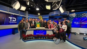 Se observa un pastel en medio y varias personas alrededor.