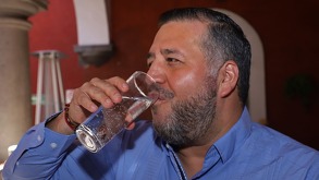 un hombre bebiendo agua mineral de tehuacán en un vaso