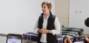 Selina Bremer en el anuncio del albergue temporal invernal. De fondo se ven algunas camas dentro del albergue con su cobertor.