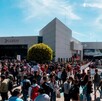 Una gran multitud de personas (visitantes de la FIL) afuera del edificio de la Expo Guadalajara bajo el sol. El edificio principal tiene una carpa blanca grande