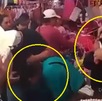Hombres cortando con tijeras y cuchillo el cabello de dos mujeres en un mercado de Puebla.
