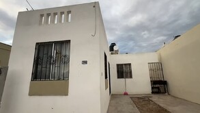 Se observa una casa color blanca con ventanas.