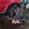 Una niña con su carriola se quedó debajo de la llanta de una camioneta color rojo al interior de un domicilio.