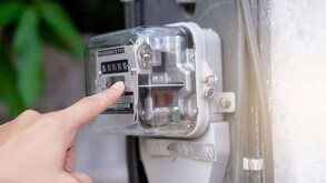 Se observa un medidor digital de la CFE y una mano.