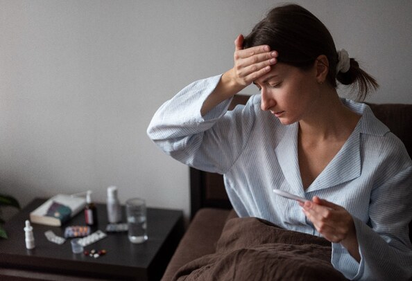 Mujer con fiebre en una cama