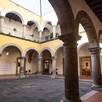 Arcos, columnas y pasillos dentro del Museo de la Ciudad de Guadalajara con paredes amarillas y un espacio libre al centro