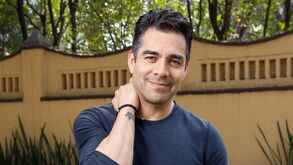 Omar Chaparro con un atuendo en color azul tocandose el cuello