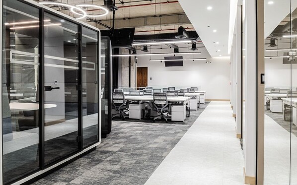 Pasillo que conduce a las oficnas de CIMA, se ve en primer plano lo que parece un armario moderno y al fondo comienzan a verse sillas y mesas.