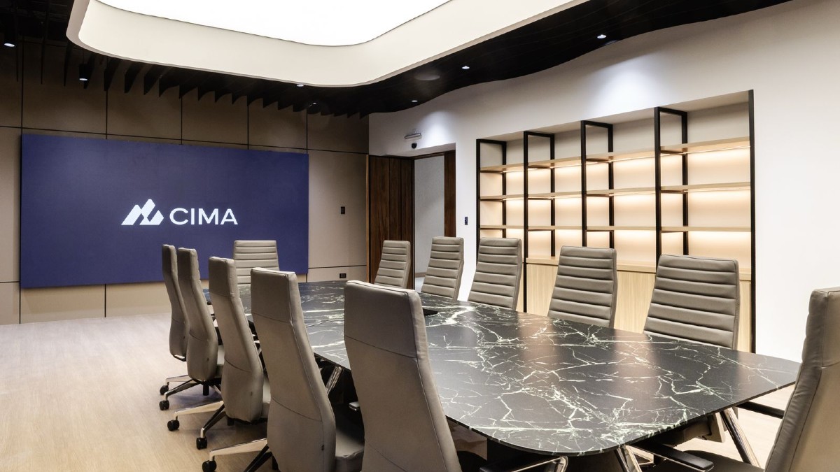 Sala de juntas en las nuevas oficinas de CIMA. Mesa central de mármol, sillas cafes y al fondo una pantalla para proyecciones.