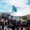 Una gran multitud de personas (visitantes de la FIL) afuera del edificio de la Expo Guadalajara bajo el sol. El edificio principal tiene una carpa blanca grande