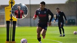 Un futbolista del Atlas (uniforme negro y rojo) corre en un campo de entrenamiento con una pelota a sus pies. El círculo insertado muestra a otro jugador, Martí