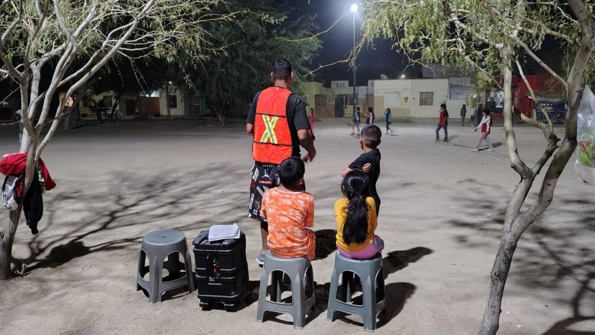 niños jugando en una cancha de fútbol que necesita ser reconstruida.