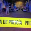 Cinta policiaca amarilla en primer plano y de fondo una patrulla de la Policía Municipal de Guadalajara estacionada detrás de un poste y un árbol
