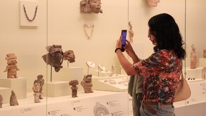 Mujer tomando una fotografía a una sección de un museo en Puebla.