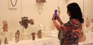 Mujer tomando una fotografía a una sección de un museo en Puebla.
