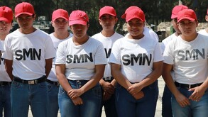 Se observan mujeres y hombres vestidos con playera blanca y cachucha roja.