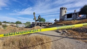 Se observa un terreno baldío con una cinta amarilla de precaución.