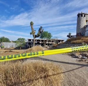Se observa un terreno baldío con una cinta amarilla de precaución.