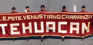 Hombres sosteniendo una manta con el nombre del Centro Escolar Venustiano Carranza.