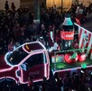 Se observa un camión iluminado de la Coca Cola y muchas personas alrededor.