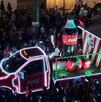 Se observa un camión iluminado de la Coca Cola y muchas personas alrededor.