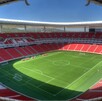 Vista panorámica y aérea del Estadio Akron (de Chivas) en Guadalajara. El campo de fútbol verde brillante está rodeado por miles de asientos de color rojo inten